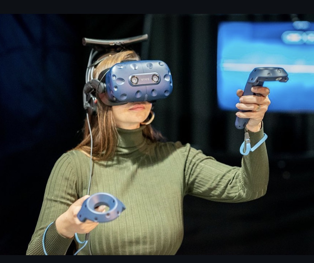 Gast mit erhobenen VR-Controllern in der Jochen Schweizer Arena München