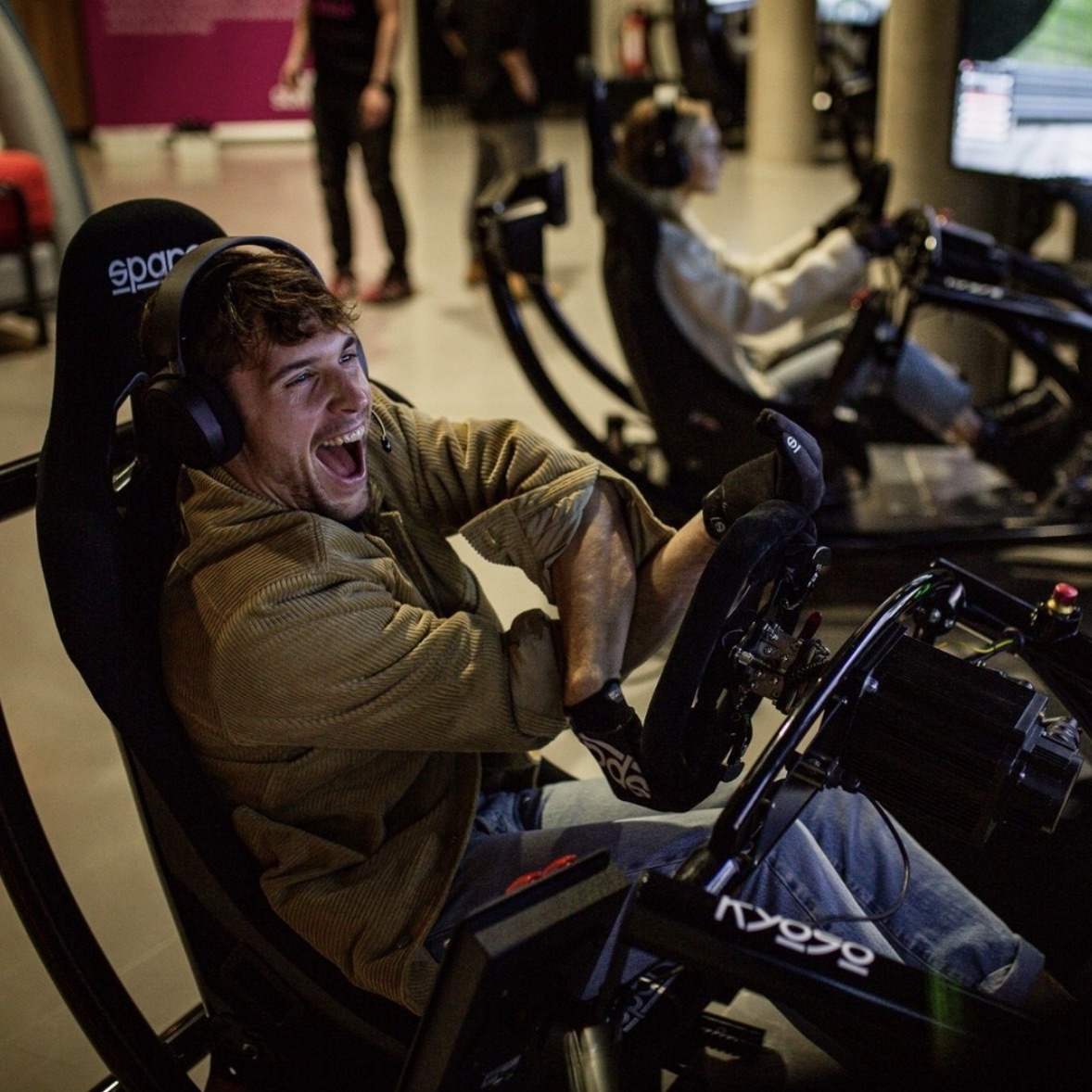 Fahrer lacht begeistert am Racing Simulator der Jochen Schweizer Arena München