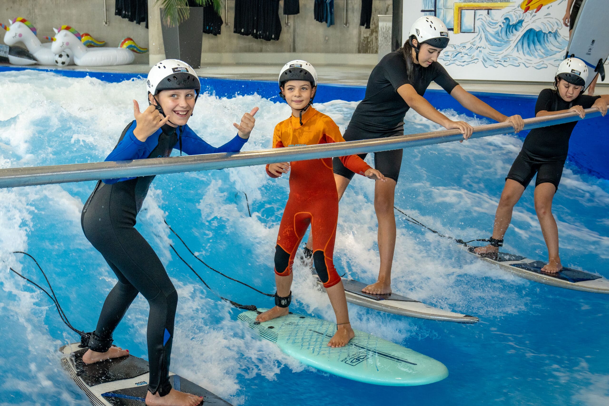 Kinder surfen an der Haltestange